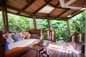 a living room with a couch on a wooden deck at Hotel Aguas Claras Member of the Cayuga Collection in Puerto Viejo