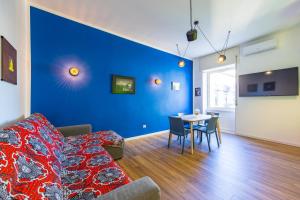 un soggiorno con divano e parete blu di The Place a Napoli