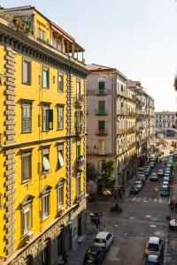 un edificio giallo su una strada cittadina con auto parcheggiate di The Place a Napoli