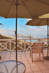 a patio with two umbrellas and a table and chairs at Northside Studio Vacation Rental in Nazareth