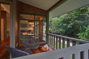 un porche cubierto con sillas y mesa en Senda Monteverde Hotel Member of the Cayuga Collection en Monteverde Costa Rica