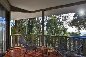 a porch with two chairs and a table on it at Senda Monteverde Hotel Member of the Cayuga Collection in Monteverde Costa Rica