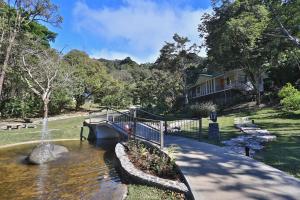 a small pond with a fountain in a park at Senda Monteverde Hotel Member of the Cayuga Collection in Monteverde Costa Rica