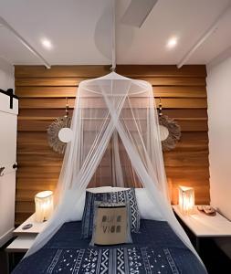 Schlafzimmer mit einem Bett mit Moskitonetz in der Unterkunft MINI UP! Acogedora casita para 2 personas con AC in Cocles