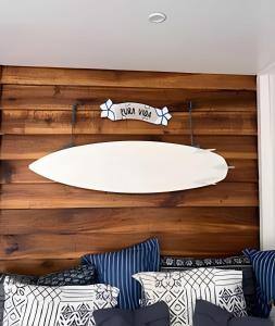 a surfboard on the wall of a room with pillows at MINI UP! Acogedora casita para 2 personas con AC in Cocles
