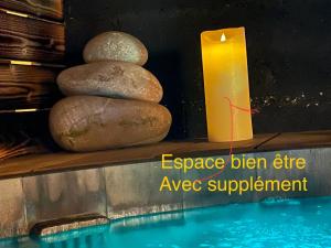 a candle and three rocks next to a swimming pool at Kartier chambre deluxe in Plouguenast