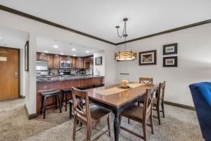 a kitchen and dining room with a wooden table and chairs at Modern 2BR Condo Near Ski Lift Walk Everywhere in Park City