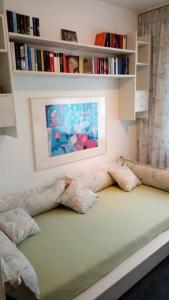 Habitación con sofá con almohadas y estante para libros. en Wohlfühlen nahe Bremen/Oldenburg, en Ganderkesee