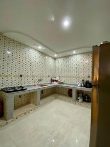 an empty kitchen with a counter and a refrigerator at RÉSIDENCE SNIYA in Dakhla