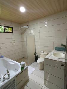 a bathroom with a tub and a toilet and a sink at Casa privada en el Bosque Nuboso Del Cocora in San Ramón