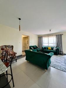 een woonkamer met een groene bank en stoelen bij PARADISE PALACE in Nairobi
