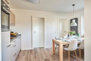 eine weiße Küche mit einem Holztisch und Stühlen in der Unterkunft Smart Resorts Saphir 506 in Winterberg