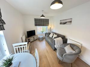a living room with a couch and a table at Bliss On The Bay in Filey
