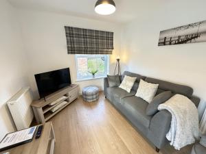 a living room with a couch and a flat screen tv at Bliss On The Bay - Part of the The Bay Filey Holiday Village with pool, gym and direct beach access, pub, restaurant, tennis and meadows walks in Filey