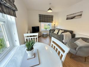 a living room with a table and a couch at Bliss On The Bay - Part of the The Bay Filey Holiday Village with pool, gym and direct beach access, pub, restaurant, tennis and meadows walks in Filey +42 photos