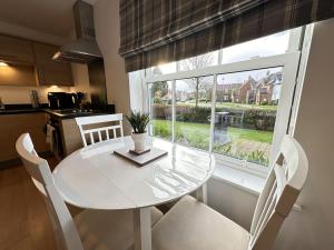a white table and chairs in a kitchen with a window at Bliss On The Bay - Part of the The Bay Filey Holiday Village with pool, gym and direct beach access, pub, restaurant, tennis and meadows walks in Filey