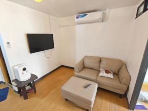 sala de estar con sofá y TV de pantalla plana en Cebu Urban Deca Homes B8 412 en Mandaue City
