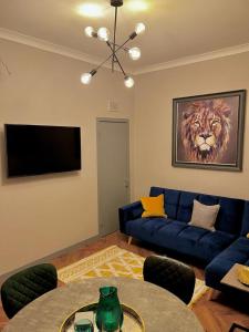 a living room with a blue couch and a television at 1 bed Apt in West End in Glasgow