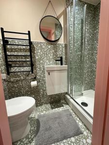 y baño con aseo, ducha y espejo. en Cozy En-suite Loft in Trendy Local en Londres