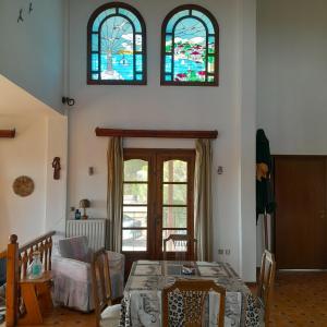 a living room with a table and two stained glass windows at Olive tree 5 bedroom VIlla in Potidaia, Kassandra Chalkidiki in Nea Potidaea
