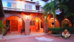 an orange building with arches and a palm tree at Casa Vieja Hotel y Restaurante in San Lorenzo