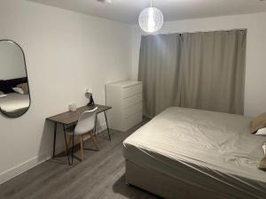 a bedroom with a bed and a desk and a mirror at Hemel Hives in Hemel Hempstead