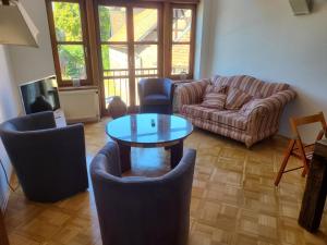 a living room with a couch and a table and chairs at Gästehaus Harzstraße in Schladen