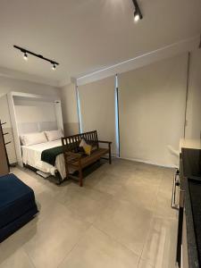 een slaapkamer met een bed en een bank erin bij Loft Alto Padrão Moderno - VN Capote in Sao Paulo