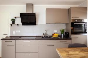 a kitchen with white cabinets and a sink and a microwave at Smart Resorts Topas 301 in Winterberg