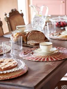 una mesa con pan y platos de comida. en Cascina Mima - Monferrato, en Quargnento