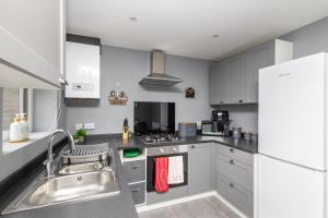 a kitchen with a sink and a stove top oven at Lofthouse M1 M62 - Parking, En-suite Bedrooms, Wi-Fi, Workspace, Smart TV's, Self Check-in, Garden - Contractors, Families, Long Stays - Alt-Stay in Wakefield
