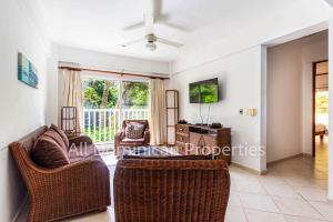 a living room with two chairs and a tv at Alicia Beach, Hispanola Sol, Sosua Center, guest friendly! in Sosúa