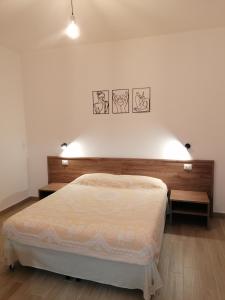 1 dormitorio con 1 cama grande y 2 mesas en CLASS ROOMS AFFITTACAMERE en SantʼAnna Arresi