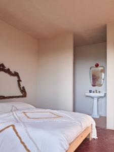 1 dormitorio con cama con espejo y lavamanos en Cascina Mima - Monferrato, en Quargnento