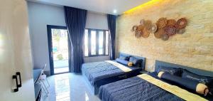 ein Schlafzimmer mit zwei Betten und einer Ziegelwand in der Unterkunft Homestay Quyên Quỳnh in Cu Lao Thu