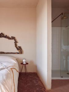 a bedroom with a bed and a glass shower at Cascina Mima - Monferrato in Quargnento