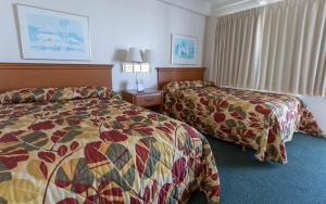 a hotel room with two beds and a window at Fish Tales Boardwalk Inn & Ocean Mecca Motel in Ocean City