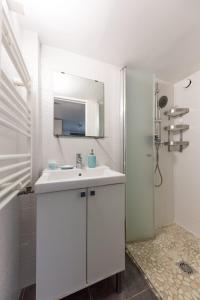 a white bathroom with a sink and a mirror at Suite spacieuse et confortable in Soisy-sous-Montmorency