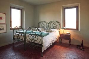 a bedroom with a bed and two windows at Cascina Mima - Monferrato in Quargnento