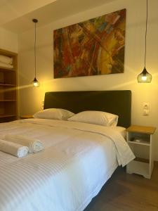 a bedroom with a white bed with a painting on the wall at Aristotelous Square n.4 in Thessaloniki