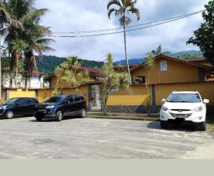 two cars parked in a parking lot in front of a house at Pousada Vila do Sonho in Paraty