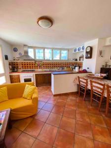 a living room with a yellow couch and a kitchen at SOLEMARE in Palau