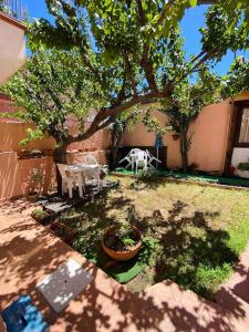 a backyard with a tree and a table and chairs at SOLEMARE in Palau