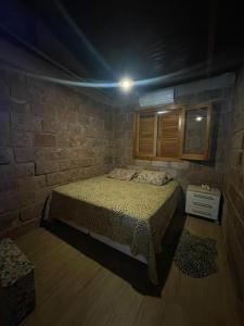 sypialnia z łóżkiem i ceglaną ścianą w obiekcie Rancho w mieście Santa Maria