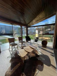 ein Wohnzimmer mit Tischen, Stühlen und Fenstern in der Unterkunft Rancho in Santa Maria