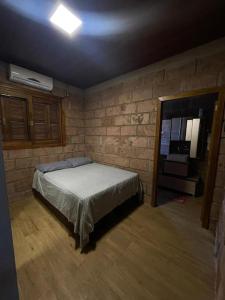 ein Schlafzimmer mit einem Bett und einer Ziegelwand in der Unterkunft Rancho in Santa Maria