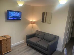a living room with a couch and a tv on the wall at 2 Bedroom Apartment on suite bathroom, Southmead Bristol in Bristol