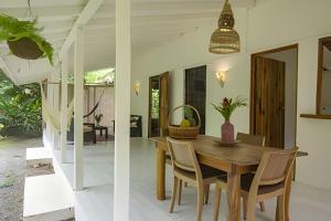 a dining room with a wooden table and chairs at Vishraam House ~ A pocos pasos de la playa in Cocles