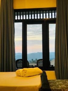 a bedroom with a bed and a large window at Cloud Nine in Kandy