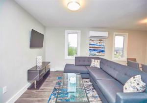 a living room with a blue couch and a table at Luxury Boutique 2 Bedroom Condo - 1B in Niagara Falls